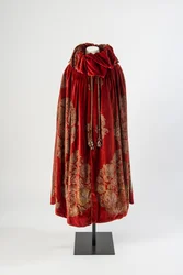 Cape en velours rouge foncé avec un motif floral pochoiré en or et argent et des glands en soie ornés de perles peintes, vers 1923 (velours)